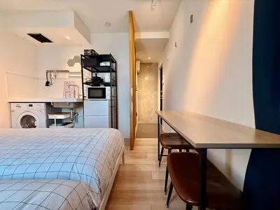 a bedroom with a bed and a table and a kitchen at Shibuya Simplex 3F, sunlight and 2 beds in Tokyo