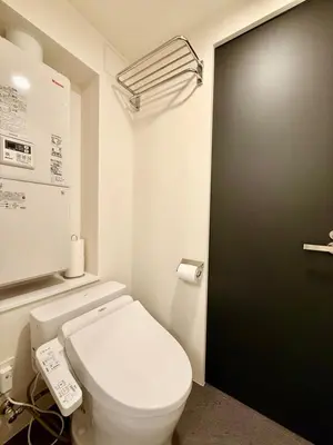 a bathroom with a white toilet and a black door at Shibuya Simplex 3F, sunlight and 2 beds in Tokyo