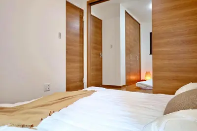 a bedroom with a large white bed with wooden headboards at \u6c60\u888b4\u4e01\u76ee\u8cb8\u5207\u4e00\u8ed2\u5bb6\u6700\u5927\u4e03\u540d in Tokyo