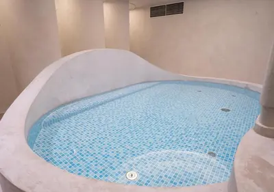a bath tub with a blue water in it at Sugoi Sauna And Stay Azabu-Juban Station, Men Only in Tokyo