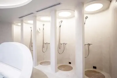 a bathroom with a shower with a toilet and lights at Sugoi Sauna And Stay Azabu-Juban Station, Men Only in Tokyo