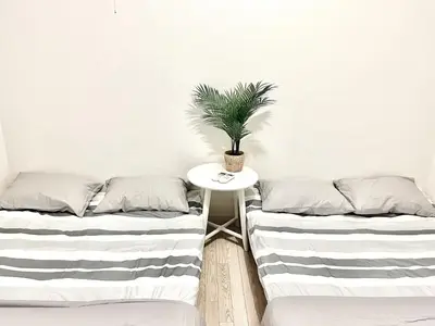 two beds in a room with a table and a plant at \u5c71\u624b\u7dda\u5927\u585a\u99c5 family land 4LDK in Tokyo