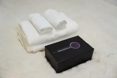a remote control sitting next to two towels and a box at \u56db\u5b63\u5b89\u3005 in Tokyo