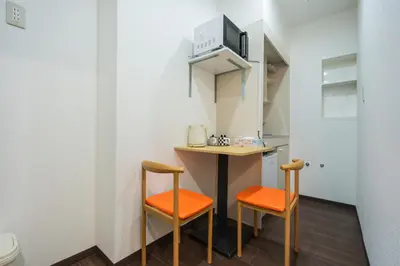 a small kitchen with two chairs and a table at \u56db\u5b63\u5b89\u3005 in Tokyo
