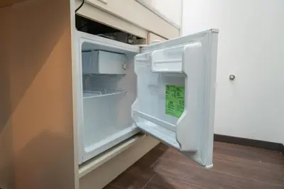 an empty refrigerator with its door open in a room at \u56db\u5b63\u5b89\u3005 in Tokyo
