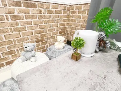 two teddy bears sitting on pillows in front of a brick wall at AAo HalfSea in Tokyo