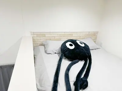 a bed with a black stuffed animal on it at AAo HalfSea in Tokyo