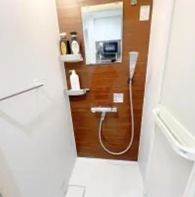 a bathroom with a shower with a hose on the wall at AAo HalfSea in Tokyo