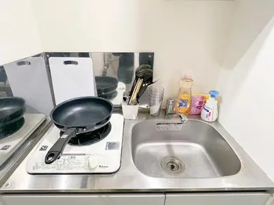 a kitchen sink with a frying pan on a stove at AAo HalfSea in Tokyo