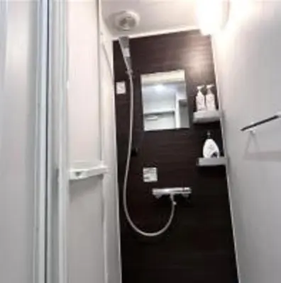 a bathroom with a shower with a hose on the wall at AYooci o7 in Tokyo