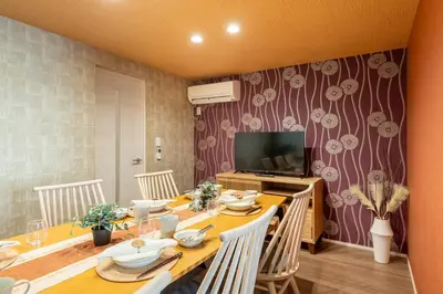 a dining room with a table with chairs and a television at Erin cort Nibankan \u30a8\u30ea\u30f3\u30b3\u30fc\u30c8\u5f10\u756a\u9928 in Tokyo