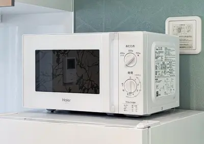 a white microwave sitting on top of a shelf at Erin cort Nibankan \u30a8\u30ea\u30f3\u30b3\u30fc\u30c8\u5f10\u756a\u9928 in Tokyo