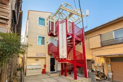 a red staircase in front of a building at Erin cort Nibankan \u30a8\u30ea\u30f3\u30b3\u30fc\u30c8\u5f10\u756a\u9928 in Tokyo