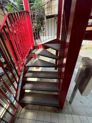 a staircase with a red railing next to a building at Erin cort Nibankan \u30a8\u30ea\u30f3\u30b3\u30fc\u30c8\u5f10\u756a\u9928 in Tokyo