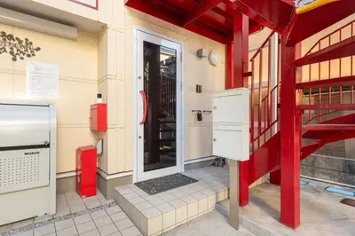 an entrance to a building with a red and white door at Erin cort Nibankan \u30a8\u30ea\u30f3\u30b3\u30fc\u30c8\u5f10\u756a\u9928 in Tokyo