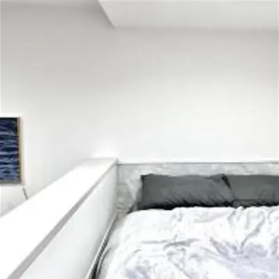 a bed in a room with a white wall at \u3072\u3060\u307e\u308a One in Tokyo