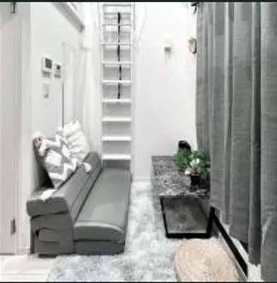 a living room with a couch and a staircase at \u3072\u3060\u307e\u308a One in Tokyo