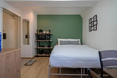 a bedroom with a bed and a green wall at CraftFlat Komagome Family 6 in Tokyo
