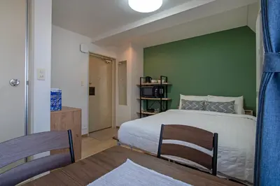 a bedroom with a bed and a green wall at CraftFlat Komagome Family 6 in Tokyo