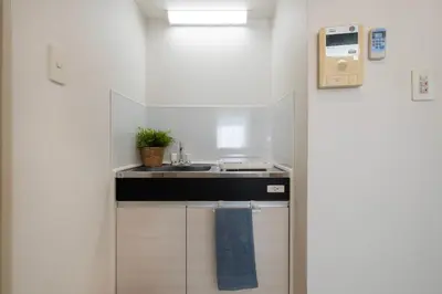 a small white kitchen with a sink and a counter at CraftFlat Komagome Family 6 in Tokyo