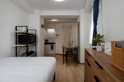 a bedroom with a bed and a desk and a kitchen at CraftFlat Komagome Family 6 in Tokyo