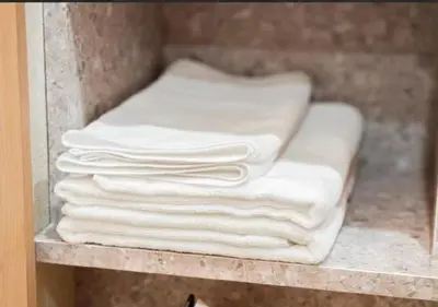 a stack of white towels on a shelf at Oshiage SAIEI Hotel 101 in Tokyo
