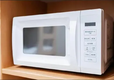 a white microwave oven sitting on top of a shelf at Oshiage SAIEI Hotel 101 in Tokyo