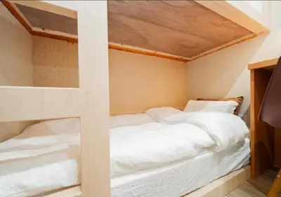 a bedroom with two bunk beds with white sheets at Oshiage SAIEI Hotel 101 in Tokyo