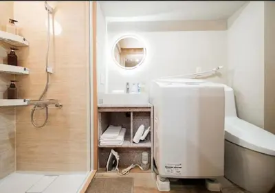 a bathroom with a shower and a toilet and a sink at Oshiage SAIEI Hotel 101 in Tokyo