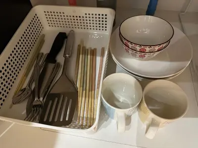 a white basket with utensils and dishes on a counter at The Birth 501 in Tokyo