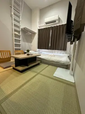 a living room with a couch and a table and a television at The Birth 501 in Tokyo