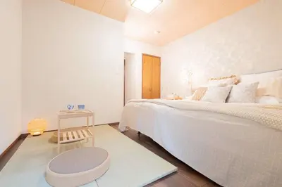 a white bedroom with a large bed and a stool at New \u65b0\u5927\u4e45\u4fdd\u8f66\u7ad92\u5206\u949f JR\u65b0\u5bbf\u8f66\u7ad915\u5206\u949f 2\u4e2a\u6d74\u5ba42\u4e2a\u536b\u751f\u95f43\u4e2a\u6d17\u9762\u53f0 in Tokyo