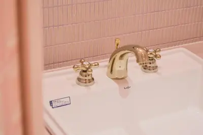 a bathroom sink with a gold faucet on it at Q-ROOMS Harajuku in Tokyo