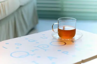 a glass cup of tea sitting on a table at Q-ROOMS Harajuku in Tokyo
