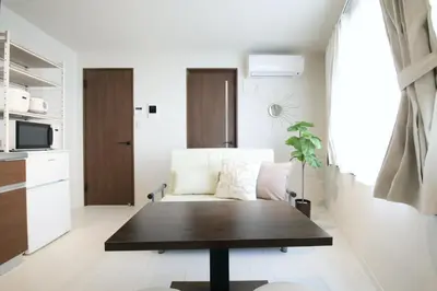 a living room with a table and a couch at Grazia\u5c0f\u5ca9 201 in Tokyo