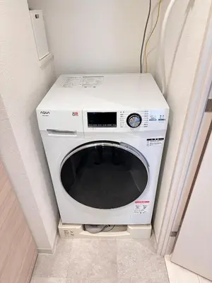 a white washing machine in a corner of a room at \u5143\u9ebb\u5e03\u30ec\u30b8\u30c7\u30f3\u30b9106 Sakura in Tokyo