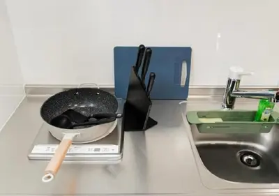 a frying pan on a scale next to a sink at Oshiage SAIEI Hotel 301 in Tokyo