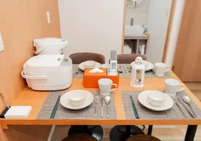 a table with plates and cups on top of it at Oshiage SAIEI Hotel 301 in Tokyo