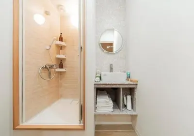 a bathroom with a shower with a mirror and a sink at Oshiage SAIEI Hotel 301 in Tokyo