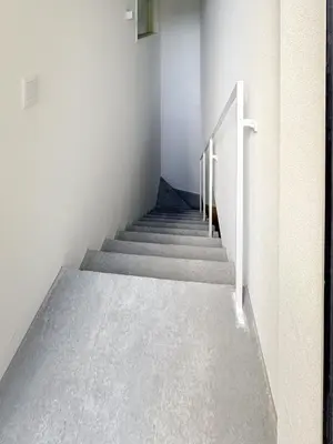 a staircase in a building with white walls and concrete floors at Ouverture102 Yoyogi Koen Station 10minute in Tokyo