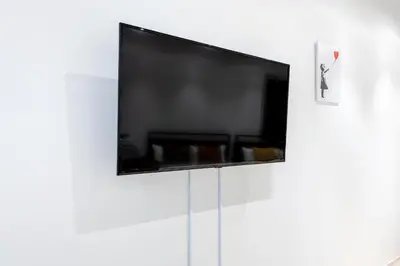 a flat screen tv on a white wall at Ouverture102 Yoyogi Koen Station 10minute in Tokyo