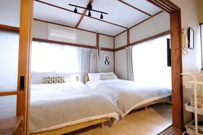 two beds in a room with two windows at Yoyogi Flats - Vacation STAY 19767 in Tokyo