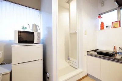 a kitchen with a refrigerator and a microwave at Yoyogi Flats - Vacation STAY 19767 in Tokyo