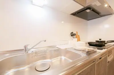 a kitchen with a stainless steel sink and a stove at JAPAN APARTMENT HOTEL Itabashi-station, Tokyo in Tokyo