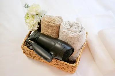 a blow dryer in a basket with towels and flowers at JAPAN APARTMENT HOTEL Itabashi-station, Tokyo in Tokyo