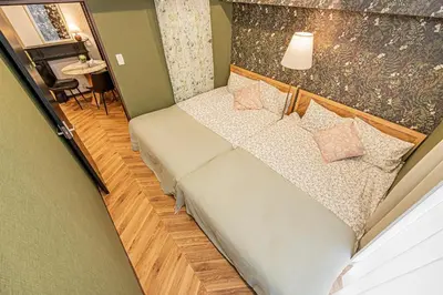 a small bed in a room with a lamp at Within easy reach of Shinjuku bustling district 4 minutes walk from nearest station 2 room apartment with lift Suitable for families and groups in Tokyo