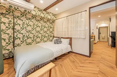 a bedroom with a bed and floral wallpaper at Within easy reach of Shinjuku bustling district 4 minutes walk from nearest station 2 room apartment with lift Suitable for families and groups in Tokyo