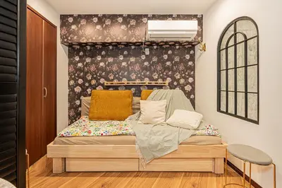 a bed in a room with a wall at Within easy reach of Shinjuku bustling district 4 minutes walk from nearest station 2 room apartment with lift Suitable for families and groups in Tokyo