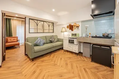 a living room with a couch and a kitchen at Within easy reach of Shinjuku bustling district 4 minutes walk from nearest station 2 room apartment with lift Suitable for families and groups in Tokyo