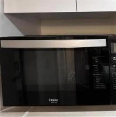 a black microwave oven sitting in a kitchen at Shinjuku sumika5 in Tokyo